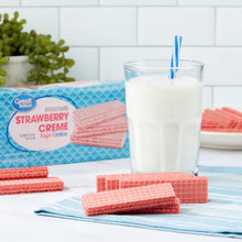 Strawberry creme wafer cookies with a glass of milk and stacked cookies on tray