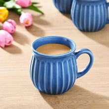Blue stoneware mug with ridged design and round handle