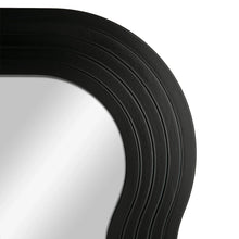 Close-up of black wavy mirror frame edge with ribbed texture