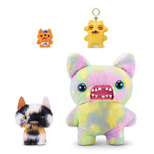 Calico cat plush with jagged teeth, wide blue eyes, and small keychain-style companion