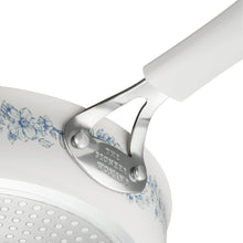 Cookware lid clamp and white handle with blue floral decoration