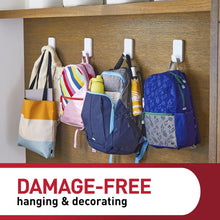 White wall hooks holding multiple bags on a wooden shelf