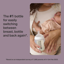Baby bottle with medium-flow nipple held during feeding