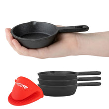 Small black cast iron skillet held in hand, with a stack of mini skillets and red mitt