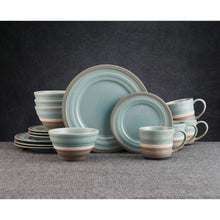 Stoneware dinnerware set in blue with cups, plates, and bowls stacked.