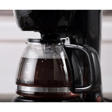 Black 5-cup drip coffee maker showing carafe with level markings and handle