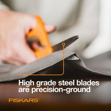 Fiskars scissors with orange handle and silver blades, cutting folded dark fabric.