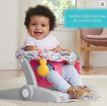 Adjustable baby floor seat with pink insert and geometric cushion, baby seated