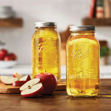 Two amber mason jars with metal lids, Ball logos on front glass