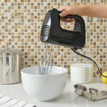 Black corded hand mixer held over a mixing bowl