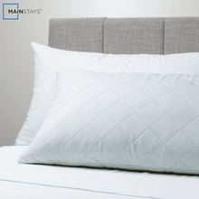 White quilted cluster king bed pillow on bed with layered bedding