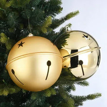 Gold jumbo bell ornaments with black star accents hanging on a Christmas tree
