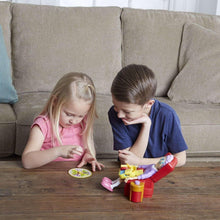 Kids using Greedy Granny toy chair and food pieces on living room table