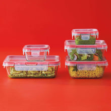 Glass food storage containers with red lids, filled with prepared meals and salads