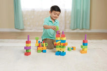 Child playing with colorful foam peg building blocks and stacked structures