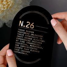 Hand holding N.26 scent booster notes label: rose, honey, oakmoss