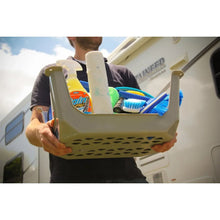 Gray plastic step stool being carried and placed beside an open cargo area