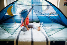 Blue kids bed tent set up over a bed, showing mesh window panels