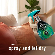 Febreze Touch fabric spray bottle with teal trigger sprayer in hand