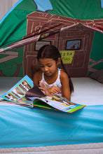 Kids’ treehouse play tent interior with open front and blue floor; child reading inside