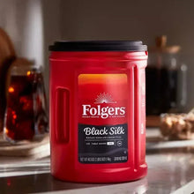 Red Folgers Black Silk ground coffee canister on counter with cup of coffee