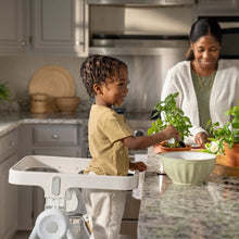 2-in-1 step stool with white tray and light wood legs, used at kitchen counter