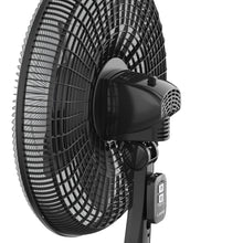 Black oscillating pedestal fan with front grille and fan blades, close-up view