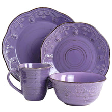 Purple stoneware dinnerware with embossed swirl motifs, includes mugs, bowls, and plates
