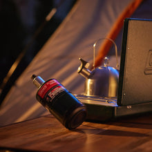 Blue propane cylinder with red Coleman label, vent valve and black base