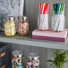 Ball wide-mouth mason jars with metal lids and bands, clear glass, on display.