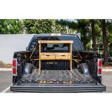 Ratchet tie-down straps securing wood and gear in a pickup bed