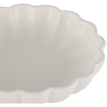 White scalloped bowl close-up with smooth glazed surface