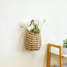 Hanging woven water hyacinth basket with brown faux leather strap and loop handle
