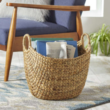 Natural woven water hyacinth boat storage basket holding books and papers