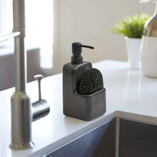 Black ceramic soap dispenser with pump and sponge holder on sink caddy