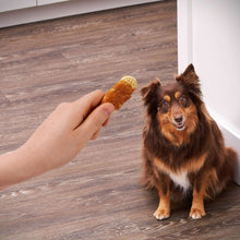 Person hand offering a biscuit-wrapped chicken dog treat to a small dog