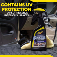 Interior detailer spray bottle with yellow nozzle, beside microfiber cloth on mat