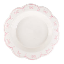 Pink pie dish with scalloped edge and ribbon bow trim along rim