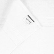 White hand towel with small fabric label on folded corner