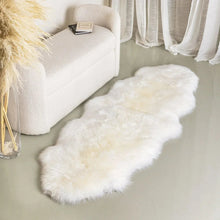 White sheepskin rug laid along the floor beside a light upholstered sofa