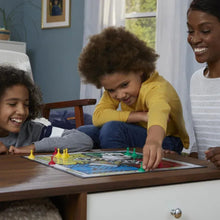 Children playing Sorry! board game on a table with red and green pawns