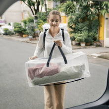 Clear moving storage bag with black handles, held in one hand