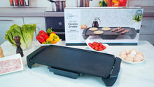 Electric griddle on countertop with removable drip tray and side control