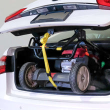 Yellow trunk strap with metal hooks securing cargo inside open car trunk