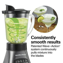 Countertop blender with clear jar filled with pale green smoothie