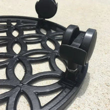 Black caster foot detail on a round plant caddy with lattice pattern