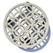 Off-white plant caddy close-up with circular lattice cutouts and decorative rim