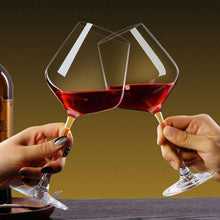 Red wine glasses, two clear goblets clinking with burgundy wine on tabletop