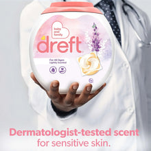 Dreft baby laundry detergent jug held by a person wearing a shirt in a close-up.