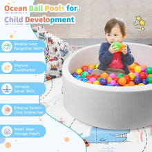Gray foam ball pit with toddler playing among colorful balls, front view